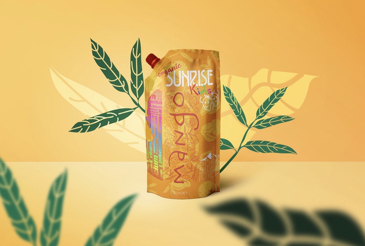 Orange Sunrise Kids mango juice pouch on a warm yellow background with illustrated green leaves