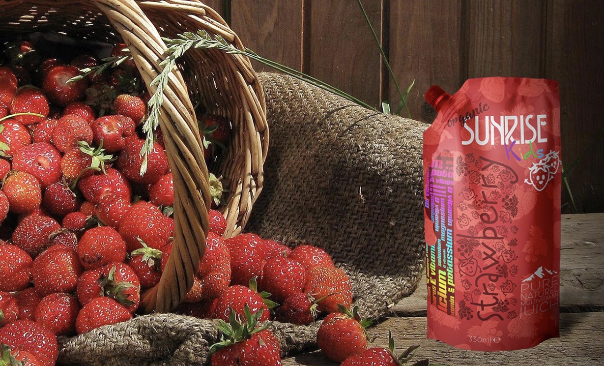 Sunrise Kids strawberry pouch beside a wicker basket of fresh strawberries on rustic wood