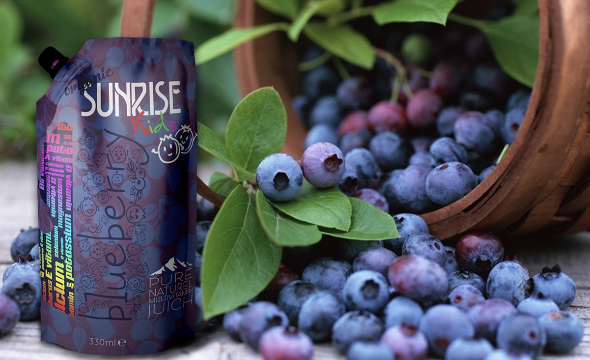 Sunrise Kids blueberry pouch beside a spilled basket of fresh blueberries